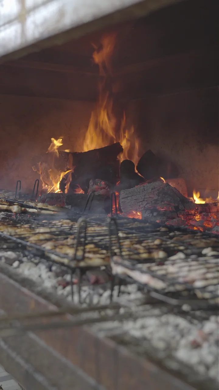 Fuego y parrillas en la zona de brasas del asadero